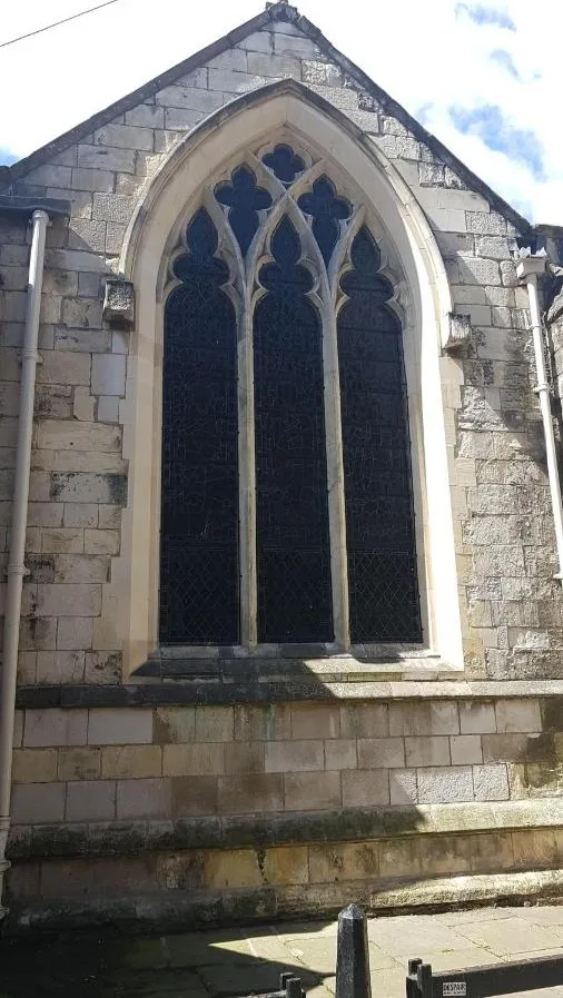 A historic building façade with a large window at Hocus Pocus Tiny Hotel, York
