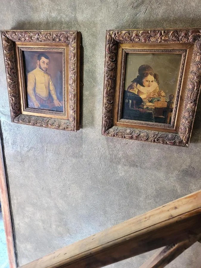 Two period portrait paintings on a wall at Hocus Pocus Tiny Hotel, York